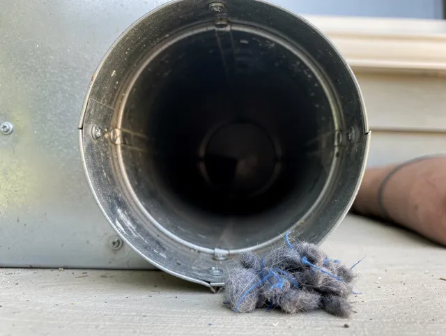 Akron Dryer Vent Cleaning technician using specialized equipment to clear severe dryer vent blockage in Akron